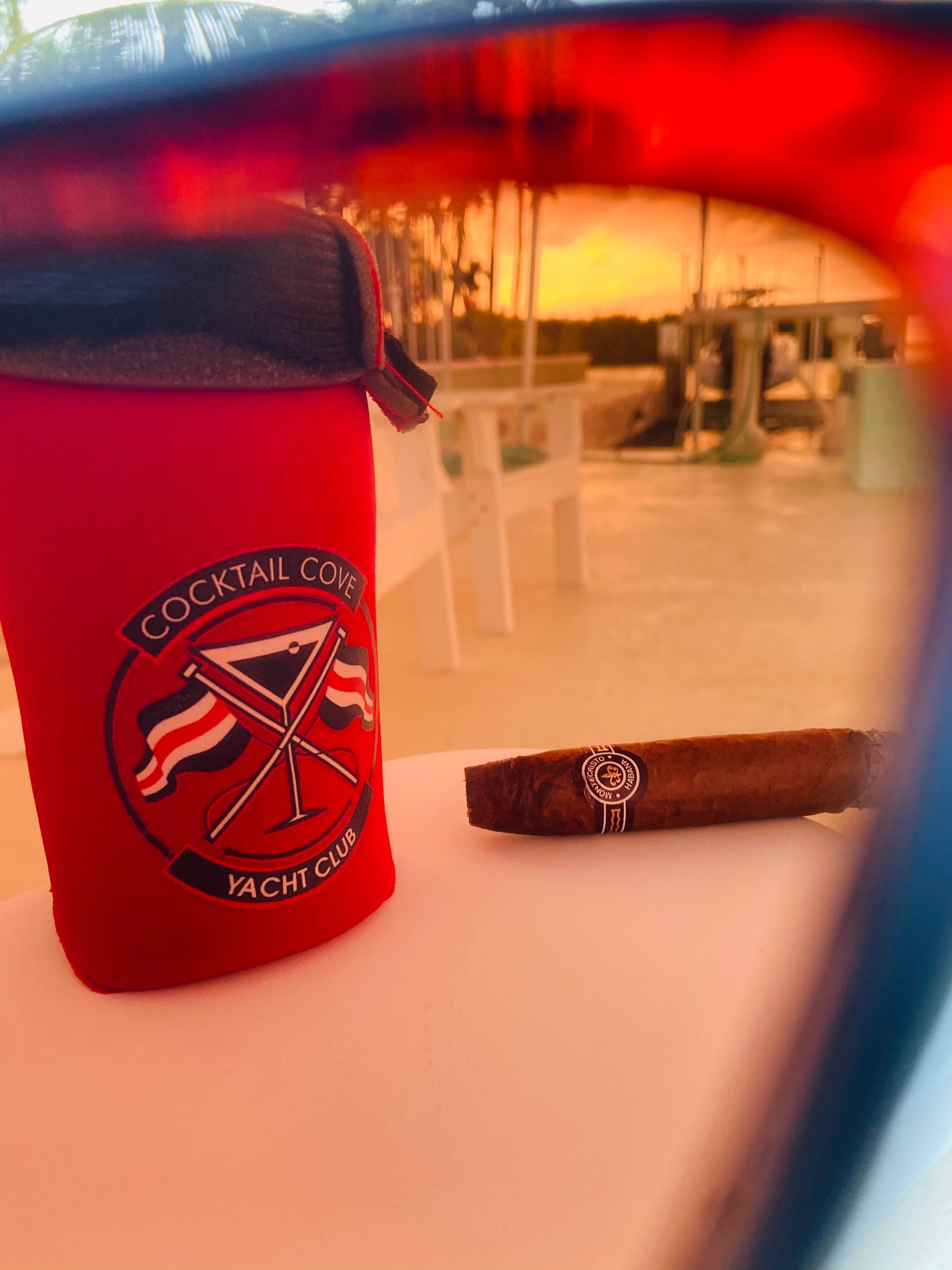 Koozie and cigar on the dock, seen through a pair of sunglasses